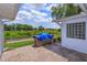 Brick patio with scenic waterway view and outdoor grilling area under a blue tarp at 1110 Fairfax St, Leesburg, FL 34748