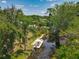 Aerial view featuring a boat docked on the canal surrounded by mature trees and lush greenery at 11114 Lake Eustis Dr, Leesburg, FL 34788