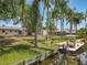 Waterfront property with lush backyard, private dock, palm trees and boat at 11114 Lake Eustis Dr, Leesburg, FL 34788