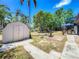 Expansive backyard features a shed, patio area with a grill, and an outdoor dining set under a blue umbrella at 11114 Lake Eustis Dr, Leesburg, FL 34788