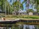 Waterfront home featuring a private dock, lush landscaping, and direct access to the canal at 11114 Lake Eustis Dr, Leesburg, FL 34788