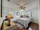 Cozy bedroom featuring wood floors, a ceiling fan, and natural light at 11114 Lake Eustis Dr, Leesburg, FL 34788