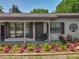 Charming home featuring a cozy porch with meticulously landscaped garden and an inviting front entrance at 11114 Lake Eustis Dr, Leesburg, FL 34788