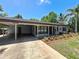 Charming home featuring a covered parking area and colorful landscaping at 11114 Lake Eustis Dr, Leesburg, FL 34788