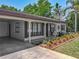 Charming home featuring a cozy porch with meticulously landscaped garden and a convenient carport at 11114 Lake Eustis Dr, Leesburg, FL 34788