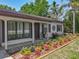 Inviting home entrance with stylish landscaping, dark shutters, and mature plants at 11114 Lake Eustis Dr, Leesburg, FL 34788