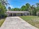 Charming single-story home with a well-manicured lawn, covered parking, and a welcoming front entrance at 11114 Lake Eustis Dr, Leesburg, FL 34788