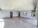 Spacious garage featuring concrete flooring, overhead lighting, and natural light with backyard access at 11114 Lake Eustis Dr, Leesburg, FL 34788