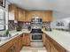 Galley kitchen with stainless steel appliances, tile backsplash and oak cabinets at 11114 Lake Eustis Dr, Leesburg, FL 34788