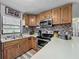 Galley kitchen with stainless steel appliances, tile backsplash and oak cabinets at 11114 Lake Eustis Dr, Leesburg, FL 34788
