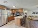 Functional kitchen with wood cabinets, stainless steel appliances, breakfast bar, and seamless flow into the dining and living areas at 11114 Lake Eustis Dr, Leesburg, FL 34788