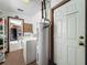 Bright laundry room featuring a washing machine, dryer, water heater, and storage shelves at 11114 Lake Eustis Dr, Leesburg, FL 34788