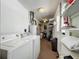 Functional laundry area with washer, dryer, water heater, and storage shelves at 11114 Lake Eustis Dr, Leesburg, FL 34788