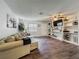 Spacious living room featuring new vinyl plank flooring, a cozy sofa, and a built-in shelving unit for stylish storage and decor at 11114 Lake Eustis Dr, Leesburg, FL 34788