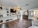 Open-concept living room boasts luxury vinyl plank flooring, built-in shelving, and easy access to the kitchen and bathroom at 11114 Lake Eustis Dr, Leesburg, FL 34788