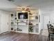 Inviting living room features luxury vinyl plank flooring, built-in shelving, ceiling fan, and seamless access to the dining area at 11114 Lake Eustis Dr, Leesburg, FL 34788
