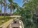 Scenic waterfront featuring a dock with a boat and lush greenery along a tranquil canal at 11114 Lake Eustis Dr, Leesburg, FL 34788