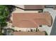 Birds-eye view of a home with patio furniture, BBQ grill, and a screened in pool in the backyard at 1121 Ricardo Ave, The Villages, FL 32159