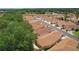 Aerial view of a well-planned community with mature trees, single-Gathering homes, and manicured lawns near a lake at 1121 Ricardo Ave, The Villages, FL 32159