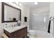 Bathroom featuring a vanity with a granite countertop, a framed mirror, and a shower-tub combination with glass doors at 1121 Ricardo Ave, The Villages, FL 32159