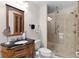 Bathroom featuring vanity with granite counters, decorative mirror and updated glass shower at 1121 Ricardo Ave, The Villages, FL 32159