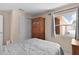 Bright bedroom featuring neutral walls, a large window, sliding closet doors, and a comfortable bed with a quilt at 1121 Ricardo Ave, The Villages, FL 32159