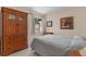 Cozy bedroom featuring a decorative dresser, artwork, a comfortable bed with a quilt, and a sunlit window with curtains at 1121 Ricardo Ave, The Villages, FL 32159