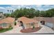 Aerial view of a well-maintained single-Gathering home with a driveway and landscaping, surrounded by mature trees at 1121 Ricardo Ave, The Villages, FL 32159