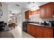 Galley style kitchen featuring tiled floors, warm wood cabinetry and breakfast nook just beyond at 1121 Ricardo Ave, The Villages, FL 32159