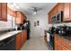 Well-lit kitchen features warm wood cabinets, dark countertops, and modern black appliances at 1121 Ricardo Ave, The Villages, FL 32159