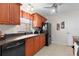 Well-lit kitchen features warm wood cabinets, dark countertops, and modern black appliances at 1121 Ricardo Ave, The Villages, FL 32159