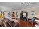 Bright living room features hardwood floors, neutral paint and comfortable seating around a large television at 1121 Ricardo Ave, The Villages, FL 32159