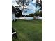 Expansive backyard featuring lush lawn, privacy fence, storage shed, and mature trees at 121 N Summit Ave, Lake Helen, FL 32744