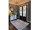 Elegant entryway with a decorative rug, modern lighting, and stylish decor at 121 N Summit Ave, Lake Helen, FL 32744