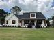 Charming, modern farmhouse-style home with red accents, a covered porch, and lush green lawn at 121 N Summit Ave, Lake Helen, FL 32744