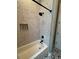 Shower featuring penny tile, black fixtures, and a built-in shelf at 121 N Summit Ave, Lake Helen, FL 32744
