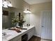 A bright bathroom features a double sink vanity with a large mirror and decorative accents at 1288 Grady Ln, Davenport, FL 33896