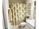 A clean bathroom featuring a shower with a patterned curtain and neutral fixtures at 1288 Grady Ln, Davenport, FL 33896