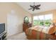 Bright bedroom with a decorative fan, large windows, and earth-toned furniture at 1288 Grady Ln, Davenport, FL 33896