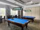 Community billiard room featuring well-maintained pool tables under elegant lighting at 1288 Grady Ln, Davenport, FL 33896