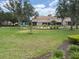 Expansive lawn with mature trees, complemented by vibrant landscaping, and a cozy seating area at 1288 Grady Ln, Davenport, FL 33896