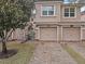 Charming townhome featuring brick driveway, attached two-car garage, and well-maintained landscaping at 1288 Grady Ln, Davenport, FL 33896