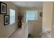 A well-lit hallway with neutral-toned walls leads to an open space, enhanced by decorative artwork at 1288 Grady Ln, Davenport, FL 33896