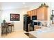 Efficient kitchen with wood cabinets, a black appliance suite, and a cozy breakfast nook at 1288 Grady Ln, Davenport, FL 33896