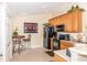 Efficient kitchen with wood cabinets, a black appliance suite, and a cozy breakfast nook at 1288 Grady Ln, Davenport, FL 33896