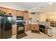 A modern kitchen featuring wood cabinetry, tile flooring, and black appliances at 1288 Grady Ln, Davenport, FL 33896