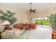 A spacious living room features sofas, vaulted ceiling, fan, and a view of the screened balcony at 1288 Grady Ln, Davenport, FL 33896