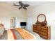 Comfortable main bedroom with a ceiling fan and dresser with a mirror at 1288 Grady Ln, Davenport, FL 33896