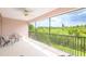 A covered balcony with a metal railing offers a beautiful view of lush green trees and sky at 1288 Grady Ln, Davenport, FL 33896