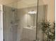 A glass shower features neutral tile, a rainfall showerhead, and built-in shelves at 1288 Grady Ln, Davenport, FL 33896